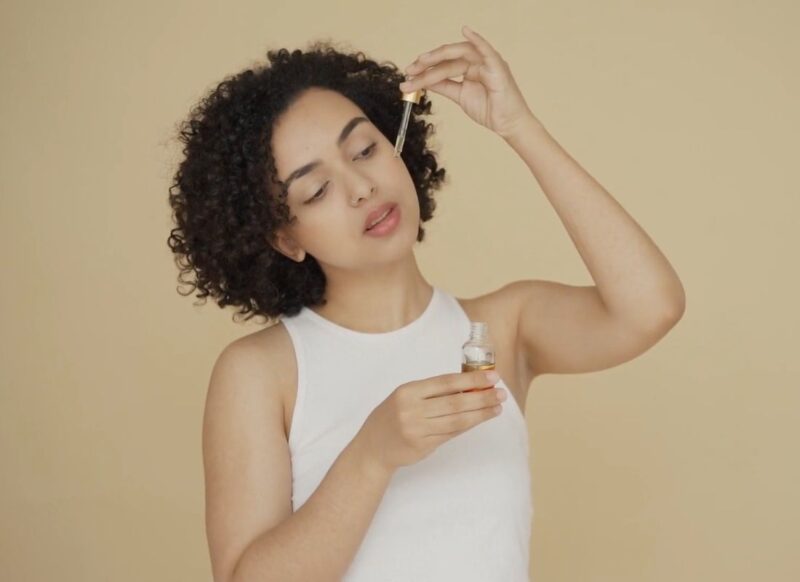 devojka nanosi ulje na kožu