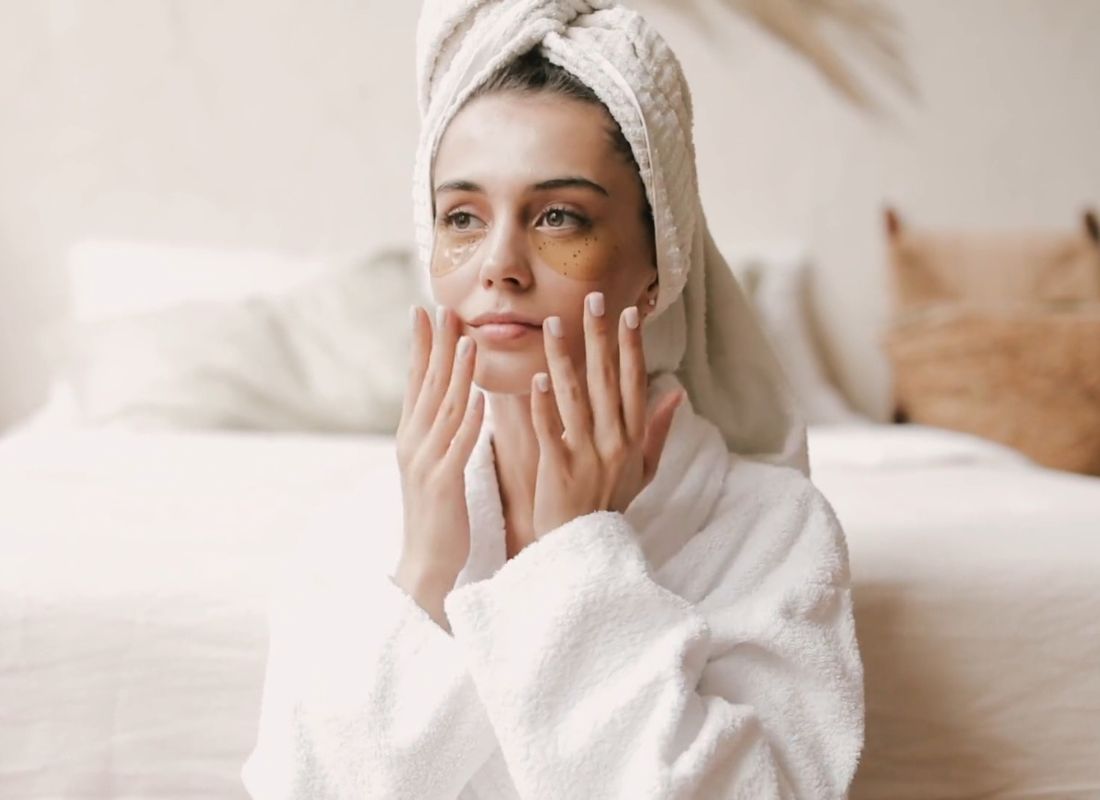 prikaz devojke u bade mantilu sa peškirom na glavi i jastučićima za uklanjanje podočnjaka