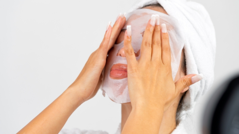 Žena stavlja masku na lice